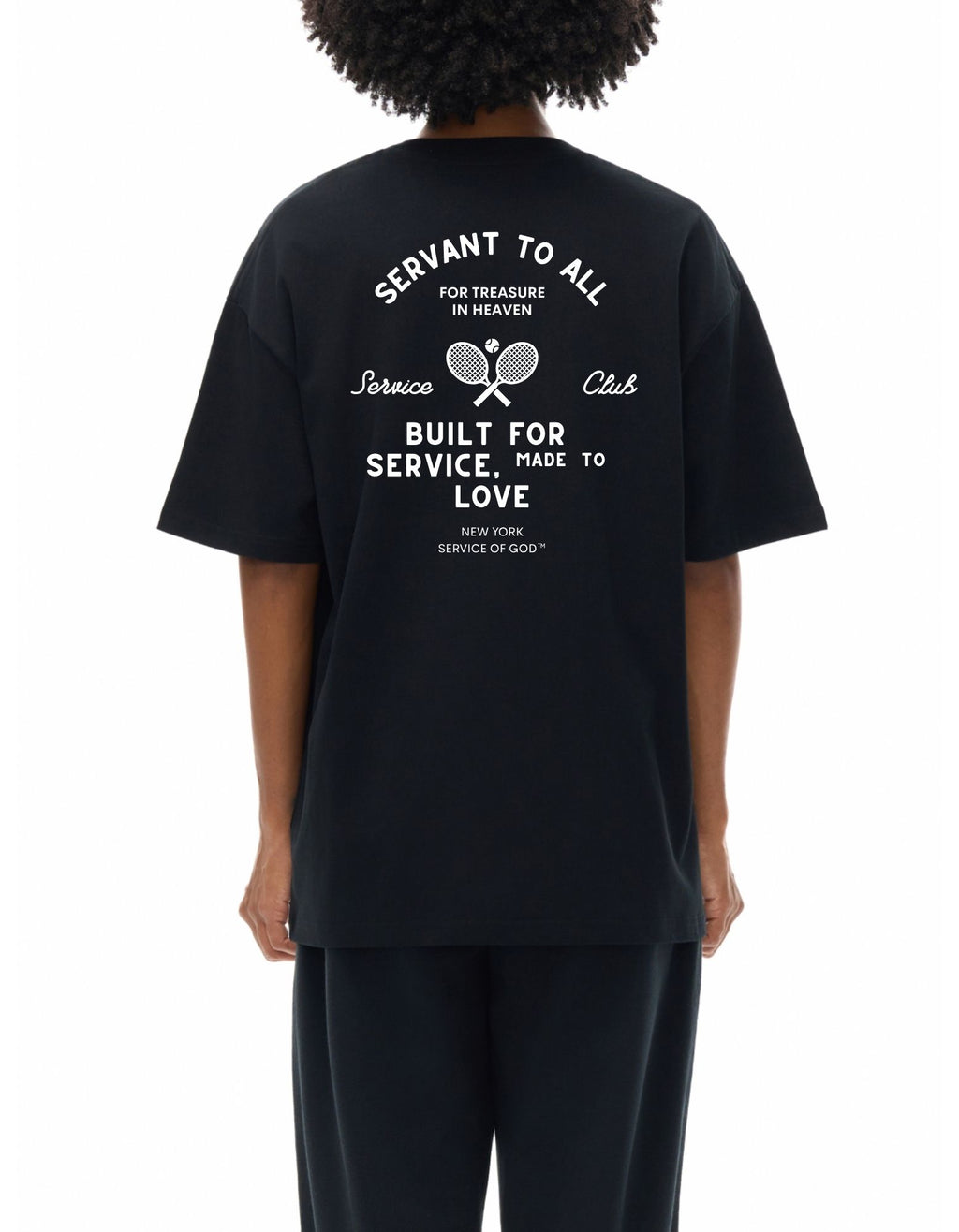 Person wearing a black t-shirt with white text and graphics on the back stating servant to all for treasure in heaven. 
