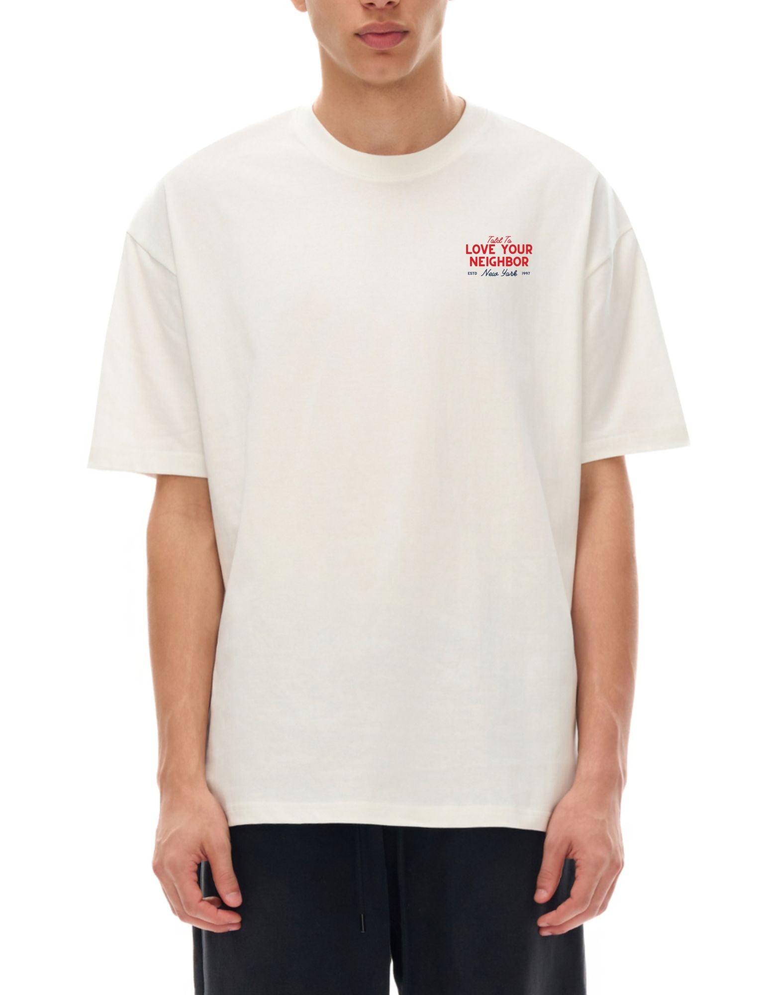 Person wearing a white t-shirt with red text saying told to love your neighbor