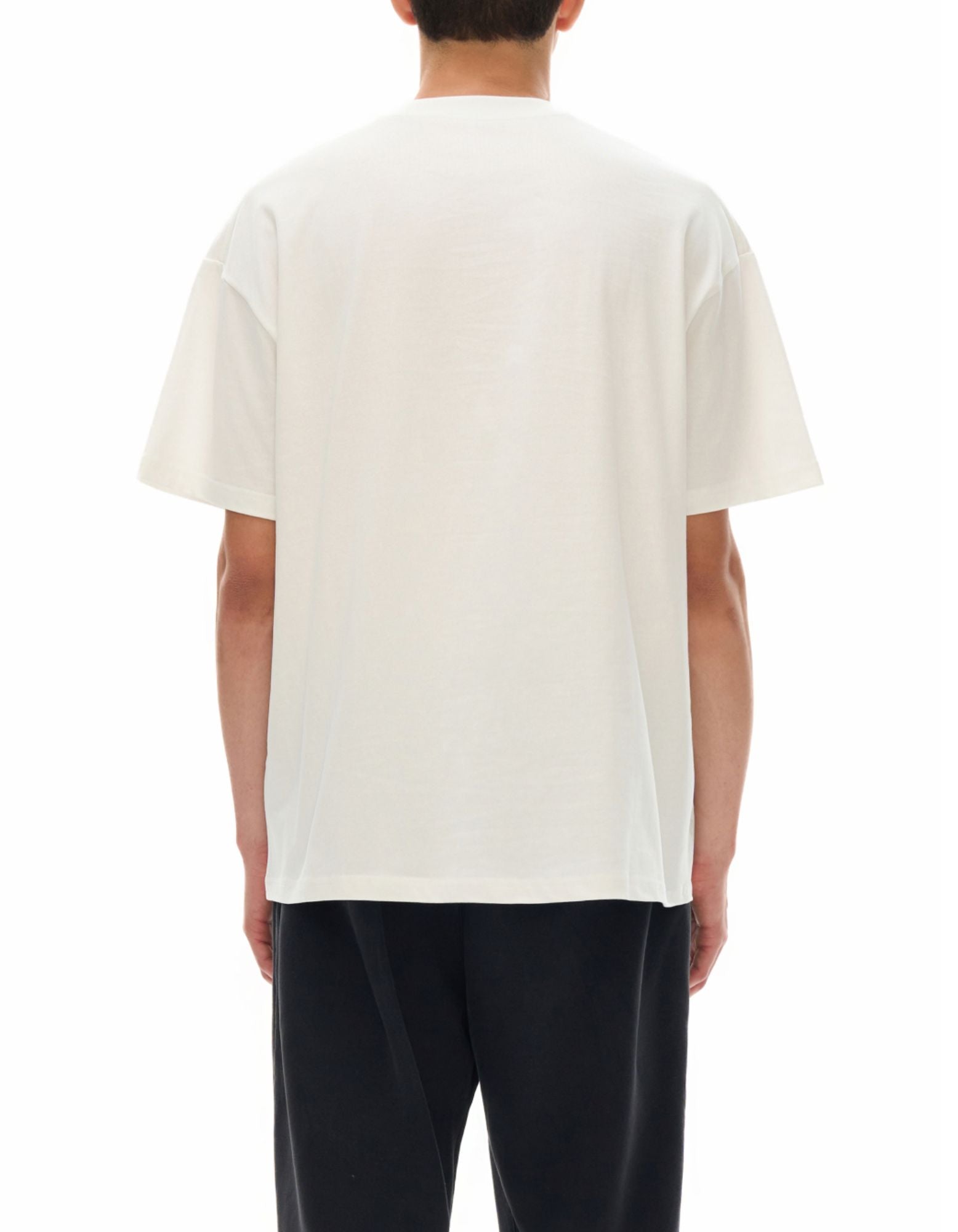 Person wearing a plain white t-shirt on a white background